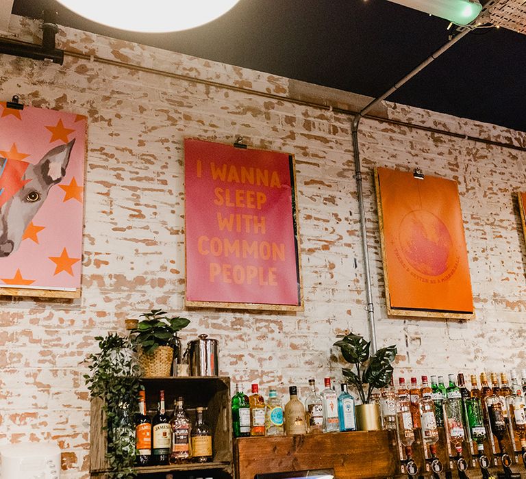 Pink and orange colourful wedding signage with lyrics from the couple's fave songs 