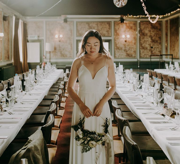 Bride in spagetti strap wedding dress with hoop bouquet at Balham Bowls Club reception