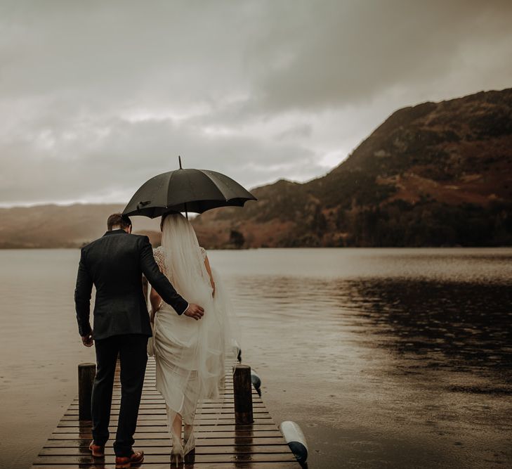 Romantic Lake District Wedding with Lake View and umberella to shelter the newly-married couple from the rain