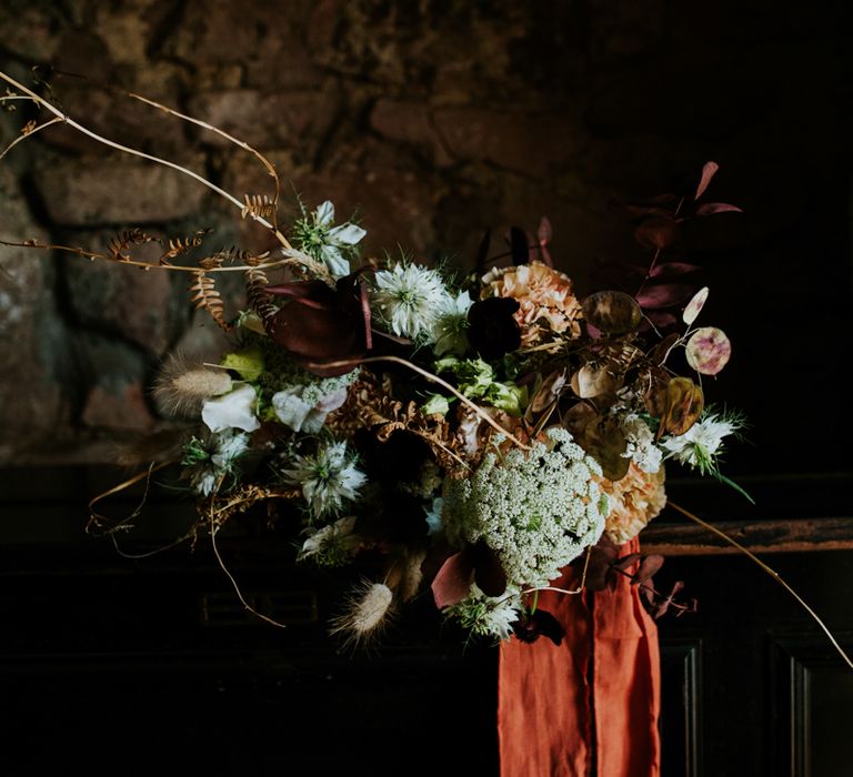 Wild wedding bouquet tied with orange ribbon 