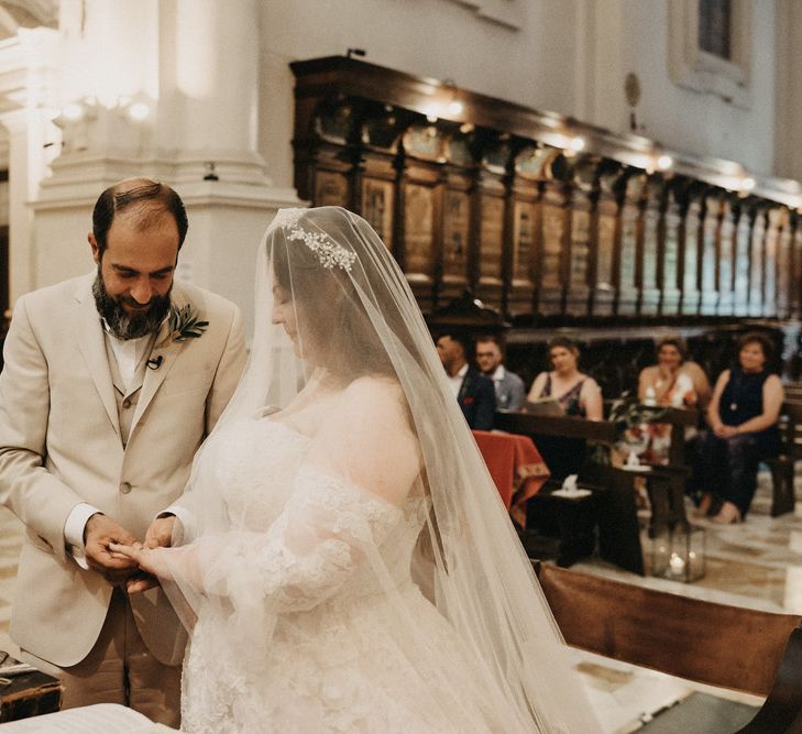 Groom slides ring on to Bride's hand in Tuscany