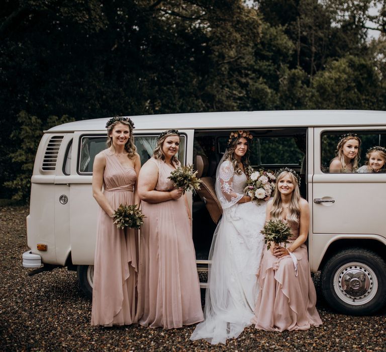 Bridal party posing with white vintage VW wedding van 