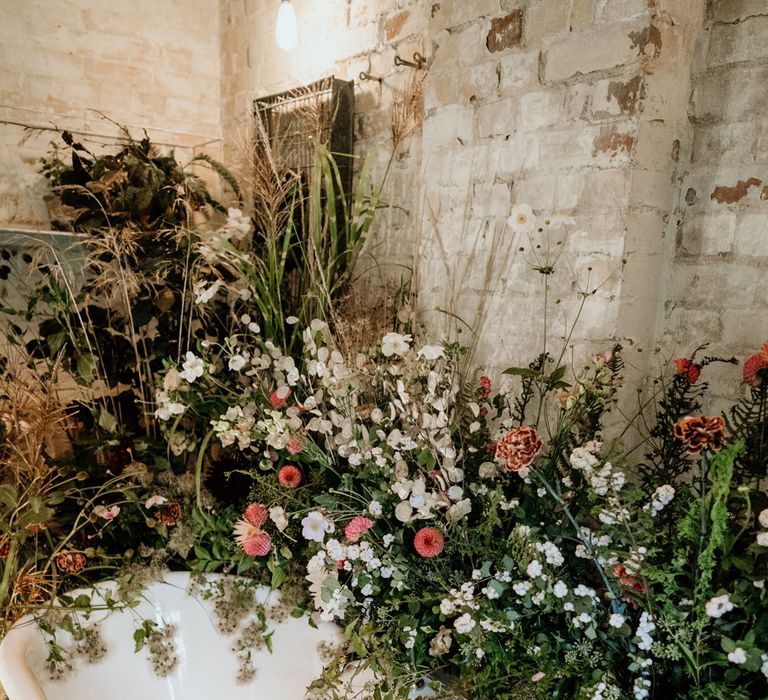 Roll top bath at Our Beautiful Glasshouse in Sussex decorated with wildflowers 