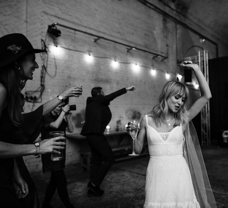 Black and white image of bride dancing at reception