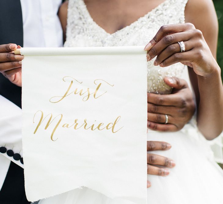 Bride & groom hold up Just Married sign 