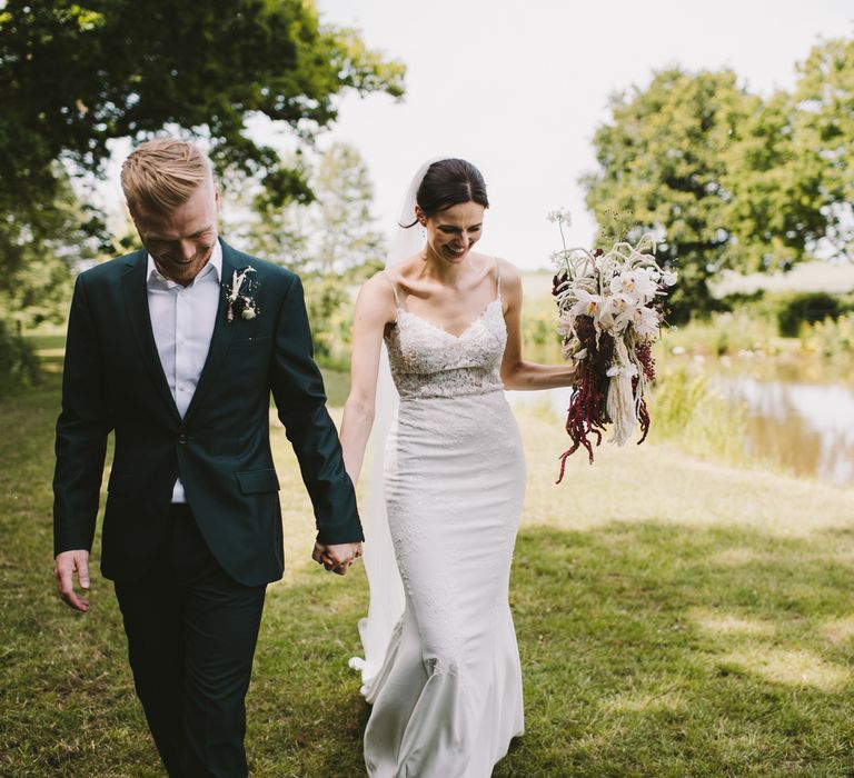 Bride & groom walk together through the countryside