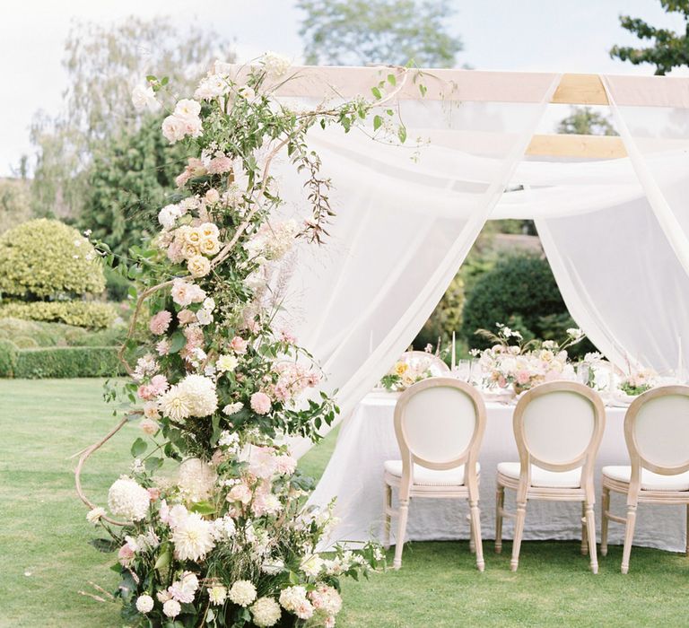 White pergola for English garden party wedding reception, decorated with climbing white and pink florals by Vervain Floral Design