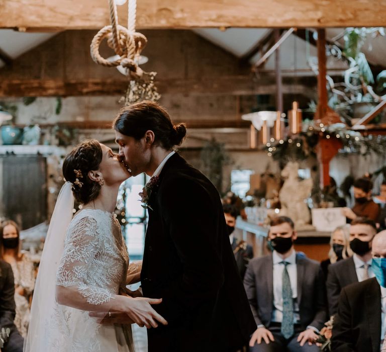 Bride and groom kissing after saying their vows at Clapton country club festive wedding