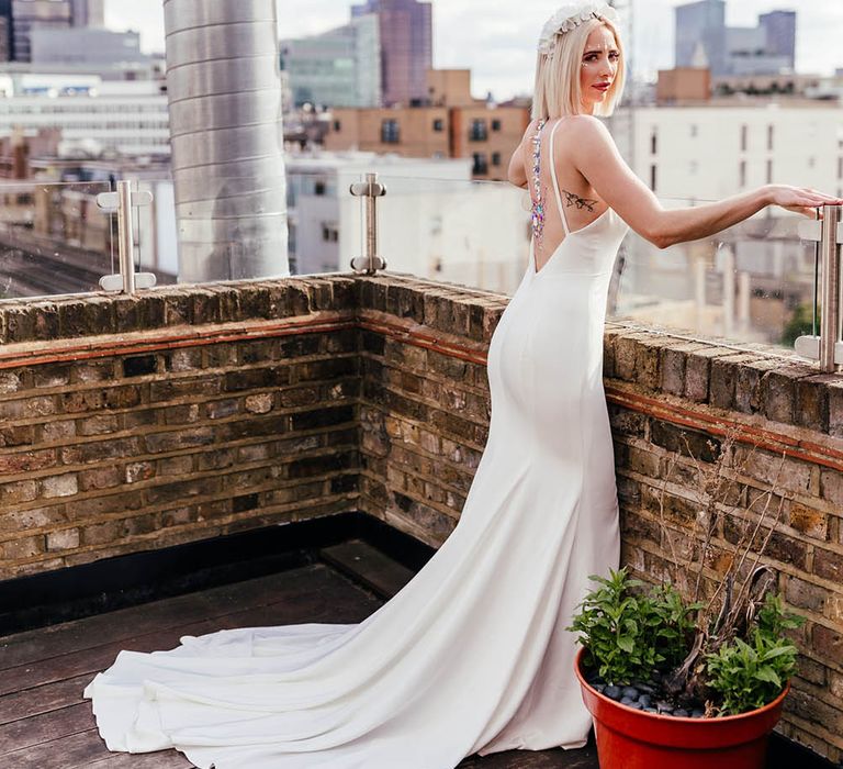 Bride in a low back wedding dress with then straps and jewel body art 