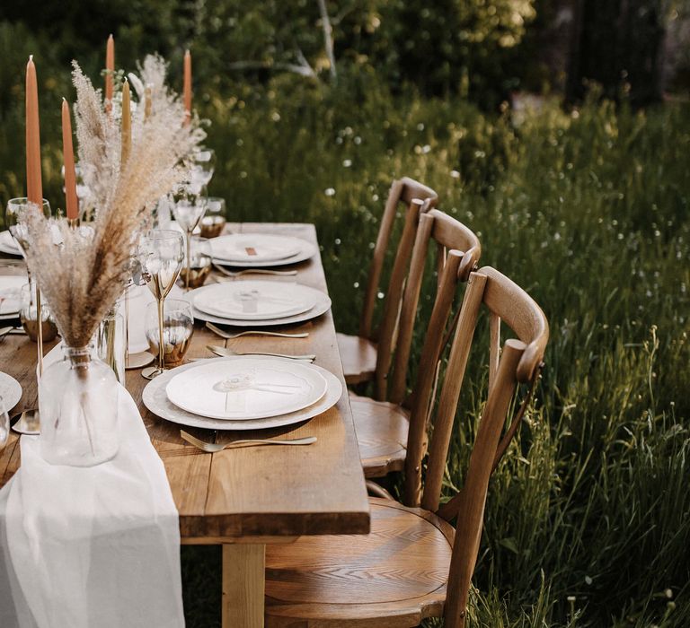 Wooden table and chairs, white tableware and lollipop wedding favours 