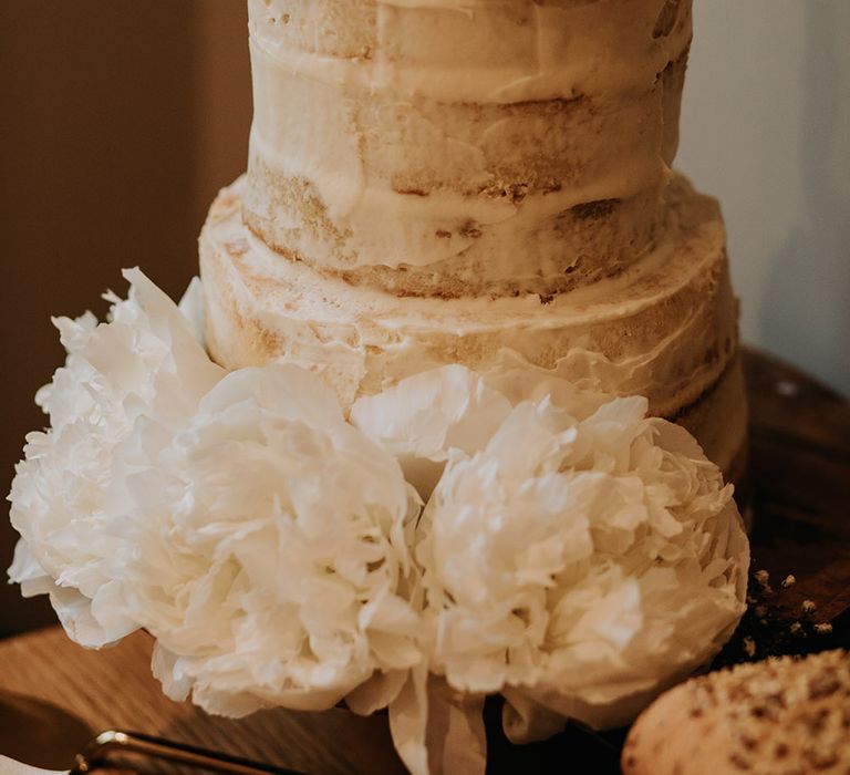 Two tier semi naked wedding cake with white peony flower decor 