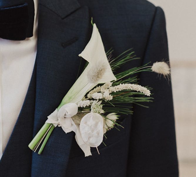 Groom in a black tuxedo with white Cala lily buttonhole