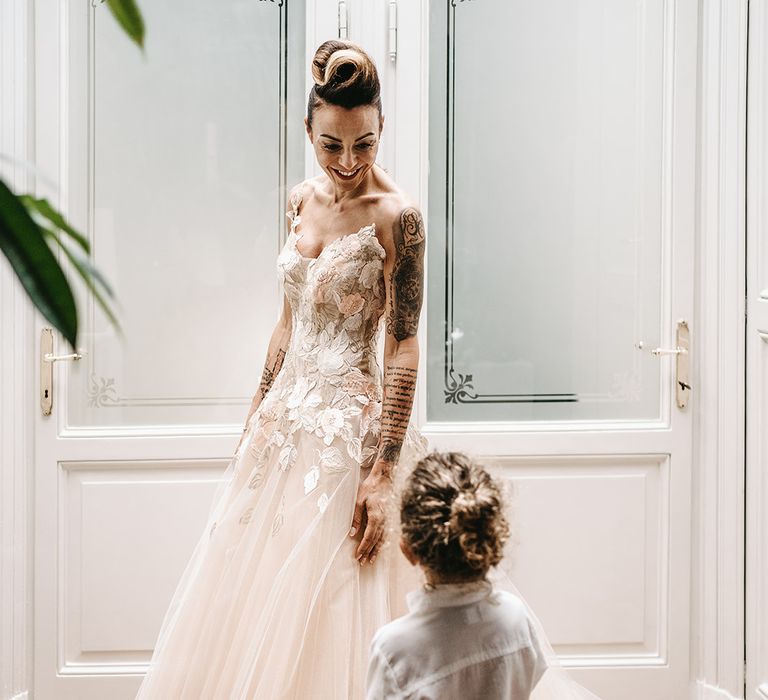 Little boy and mother smile at one another on her wedding day