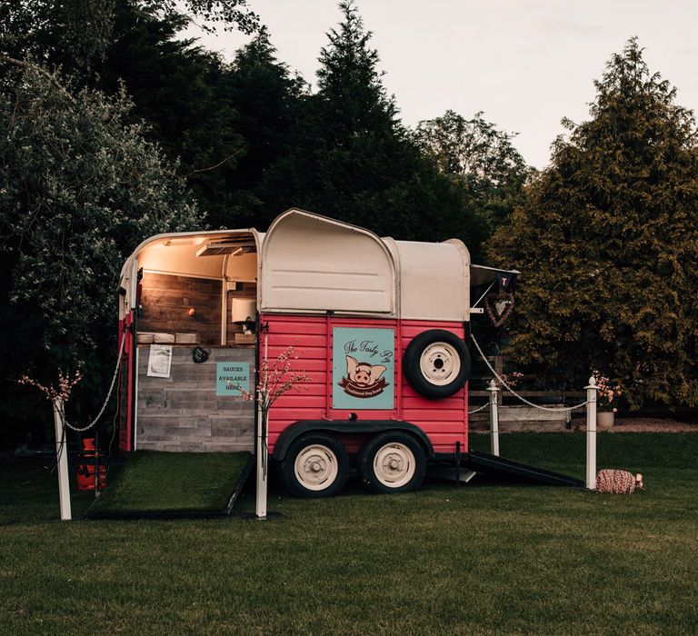 Hog roast trailer in field at outdoor wedding reception