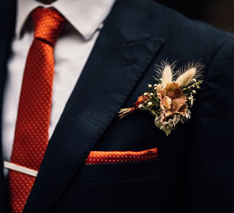 Grooms polka dot orange and white tie and pocket square with dried flower and bunny ears button hole 