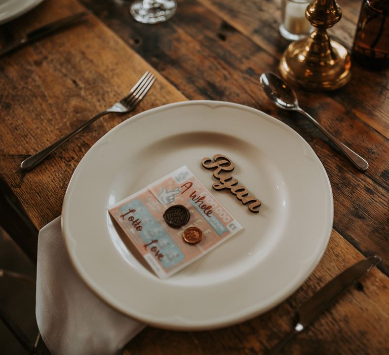 Rustic wooden wedding table setting with white plate, wooden laser cut table place name and scratch card