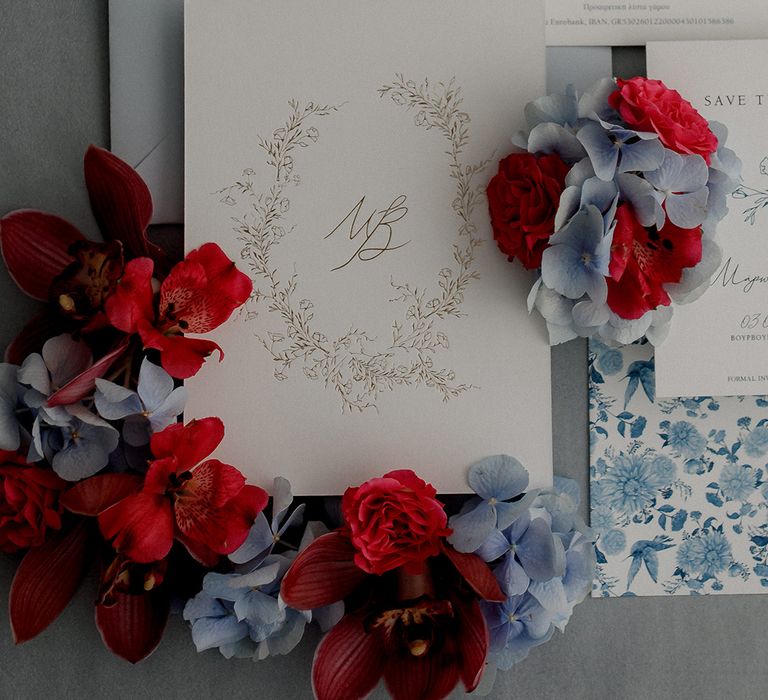 Blue & red florals surround stationery complete with gold floral design circling initials 