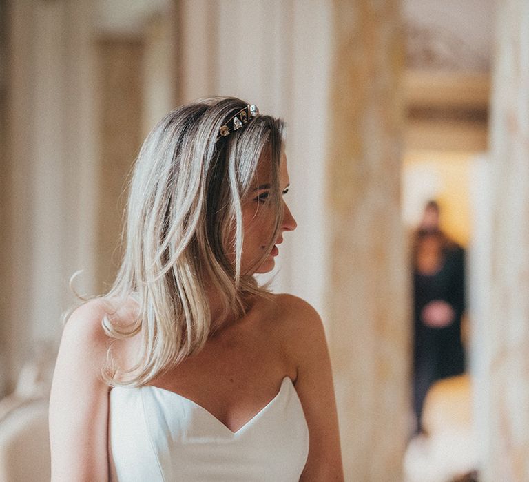 Bride wears her blonde hair in blow out complete with Nefertiti Crown and Suzanne Neville gown with sweetheart neckline 