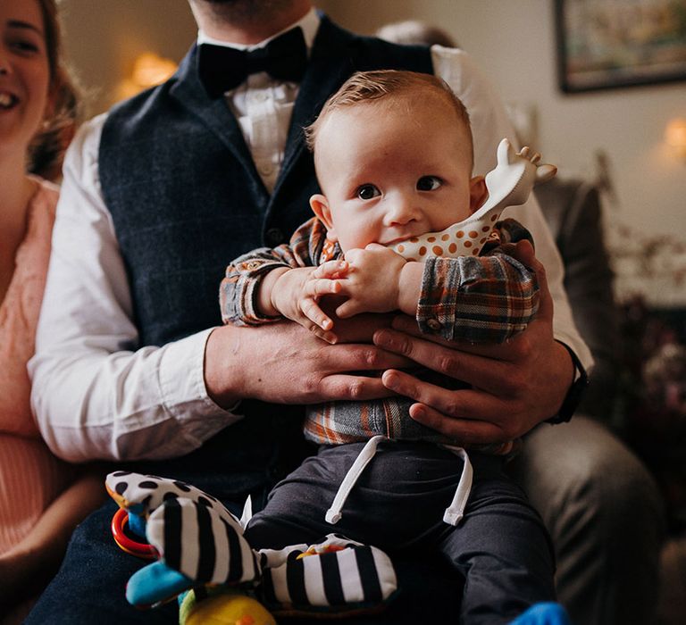 Tiny and cute wedding guest plays with his toys at country house wedding