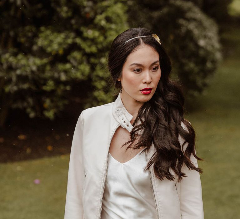 East Asian bride in a satin slip wedding dress, white jacket and metal headband 