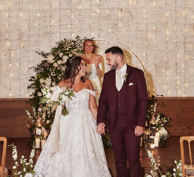 Rustic barn ceremony at East Riddlesden Hall with bride in a princess wedding dress and groom in a burgundy suit