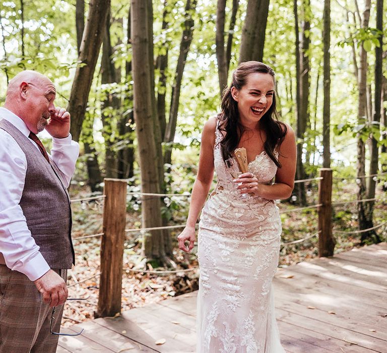 Bride laughs at her father's reaction who tears up as he sees the bride 