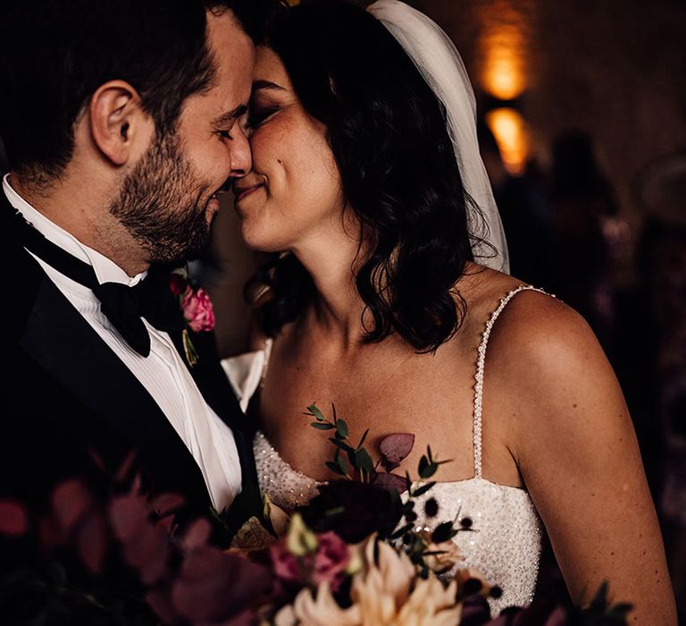 The bride and groom share an intimate moment as they lean in for a kiss 