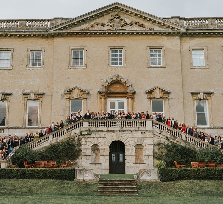 Kirtlington Park wedding venue with the wedding party standing outside the venue 