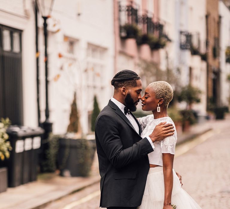 Bride and Groom in London mews wearing a bridal two piece set and black wedding suit