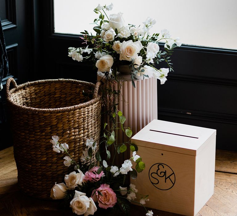 Personalised wooden box beside floral arrangements and wicker basket 