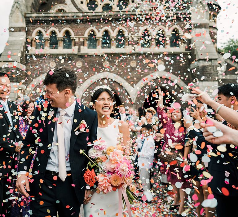 Bride & groom walk through colourful confetti exit after St Stephen's Hampstead church wedding