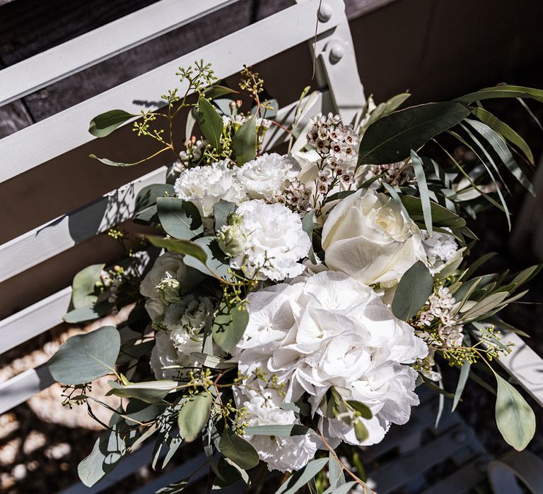 White bridal bouquet with roses and green foliage 