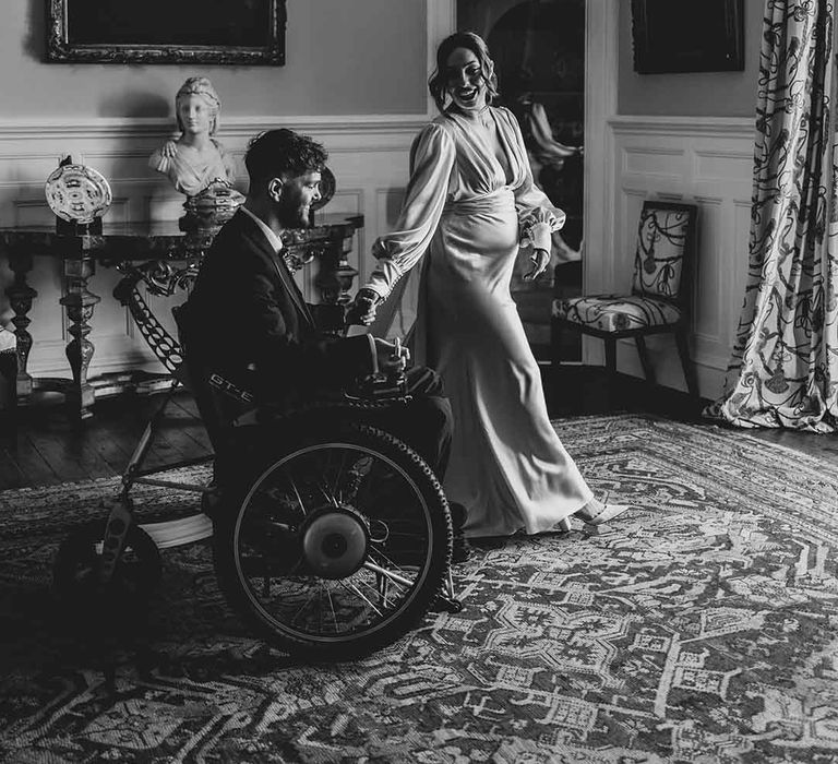 groom in a wheelchair and pregnant bride at Capesthorne Hall