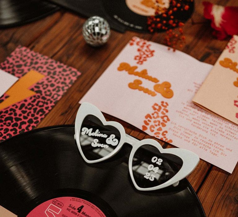 Vinyl record wedding decorations with heart shaped wedding sunglasses, leopard print wedding stationery and disco ball wedding decor