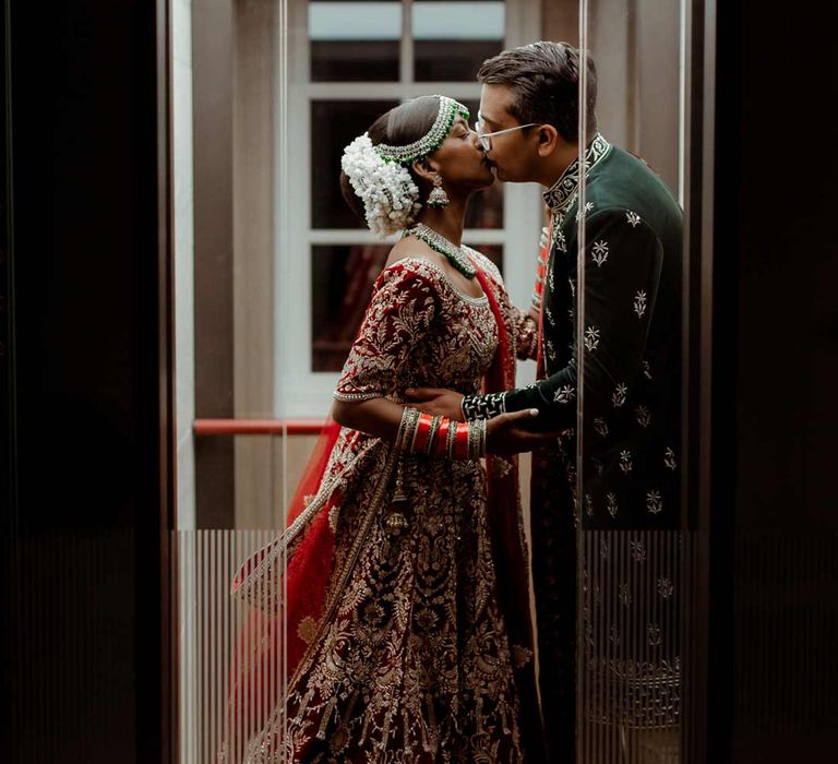 Bride in red and gold bridal lehenga and groom in deep blue sherwani at Inner Temple Hall