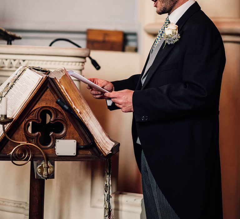 A groomsmen stands at the church to perform a wedding reading 