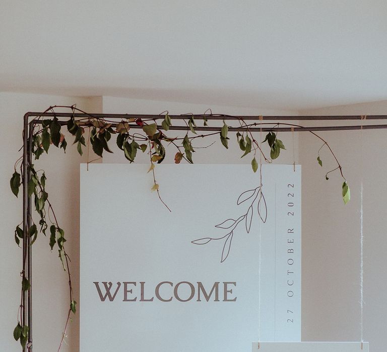 White minimalist wedding welcome sign on metal frame 