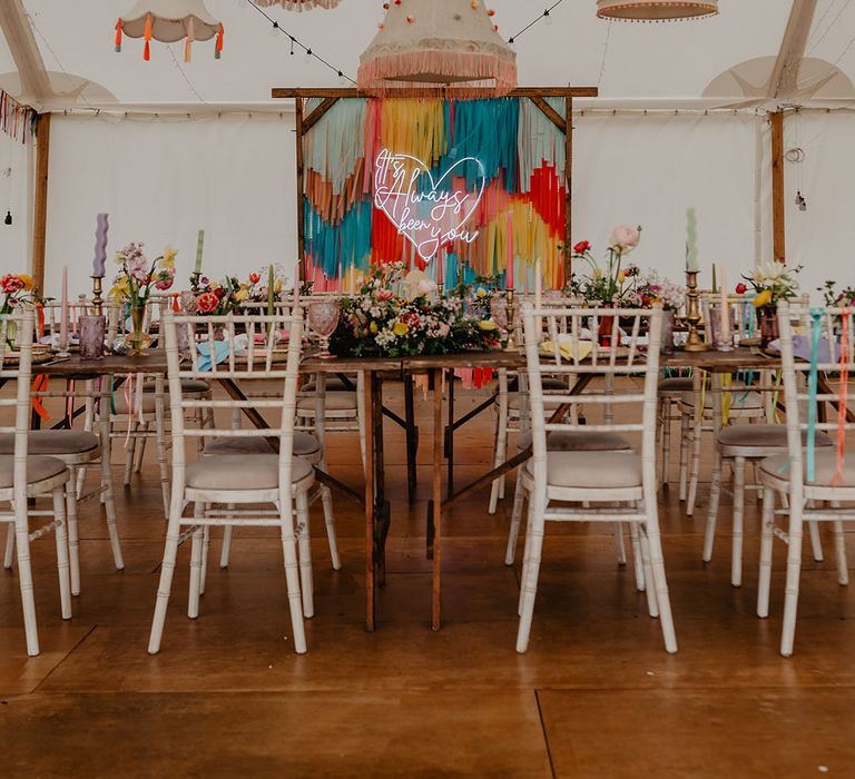 Hardwick Moat Weddings outdoor venue showcasing the marquee decorated with streamers, a neon sign, funky lampshade and more 