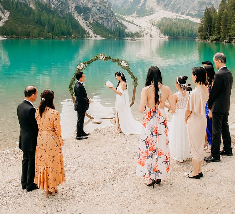 The bride and groom read their wedding vows to each other at outdoor wedding in The Dolomites in Italy 