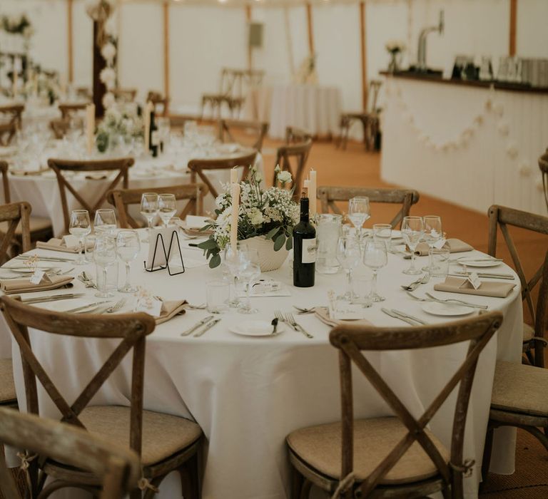 Marquee wedding breakfast with white wedding theme and table decorations with white paper lanterns and foliage 