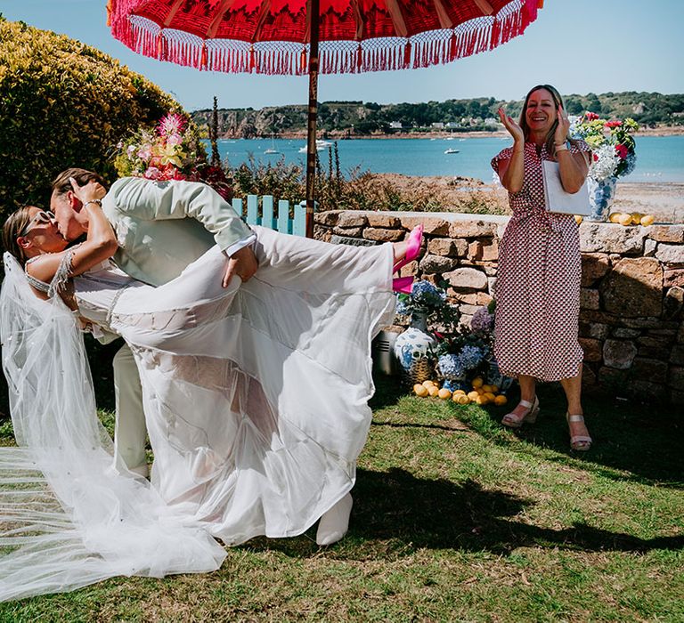 The groom sweeps the bride into a kiss for their first kiss as a married couple 