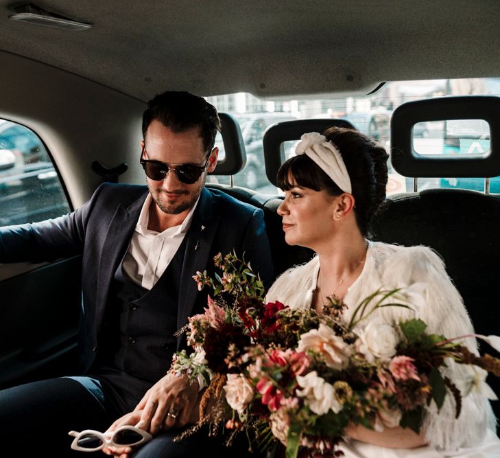 Bride and groom riding in a taxi at Liverpool wedding 