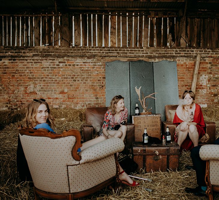 rustic wedding decor with hay bales, trunks and ornate chairs 