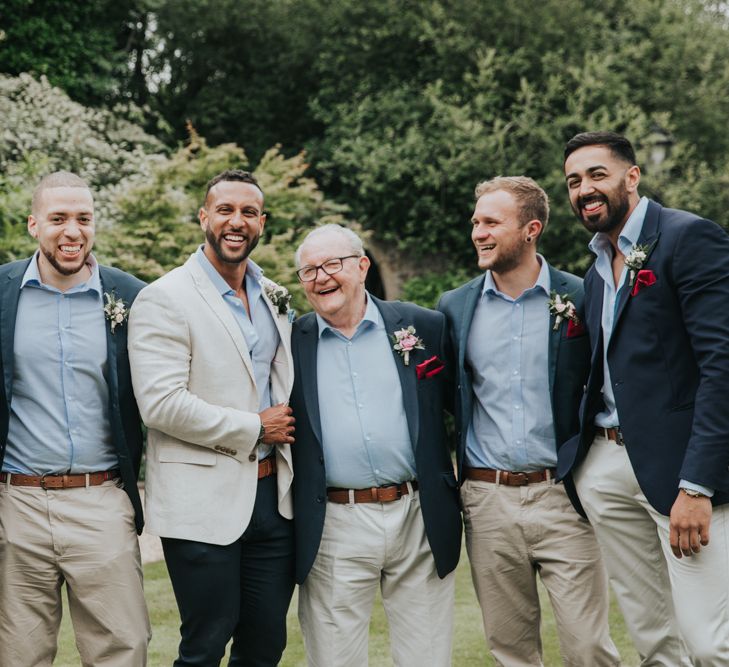 Groom and groomsmen laugh for a group wedding shot