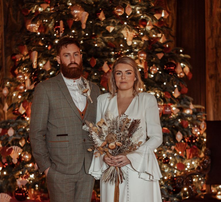 Bride & groom in front of Christmas tree