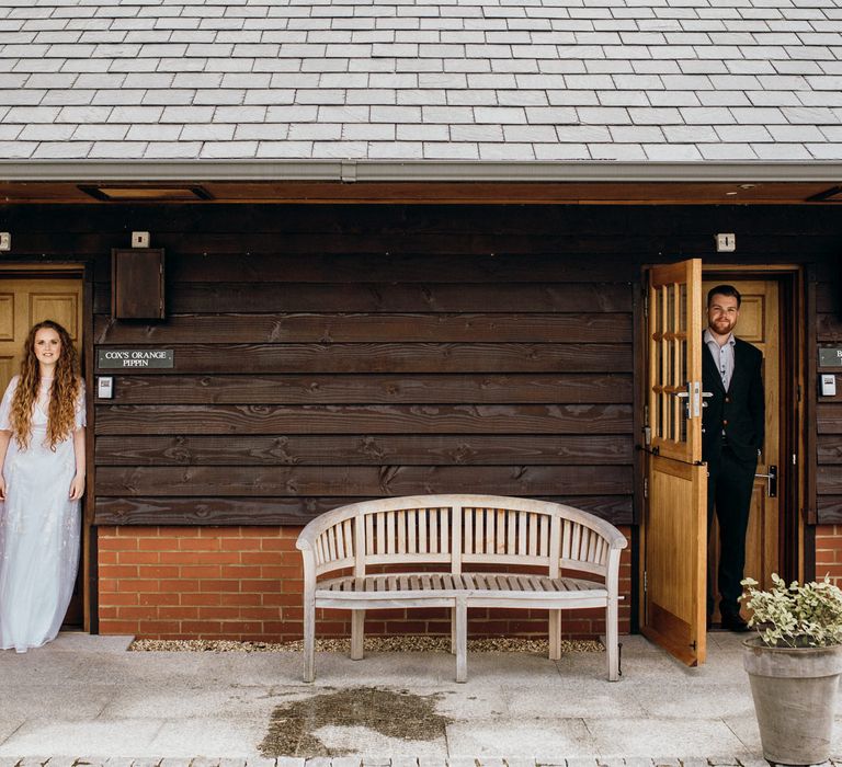 Bride & groom pose in doorway 