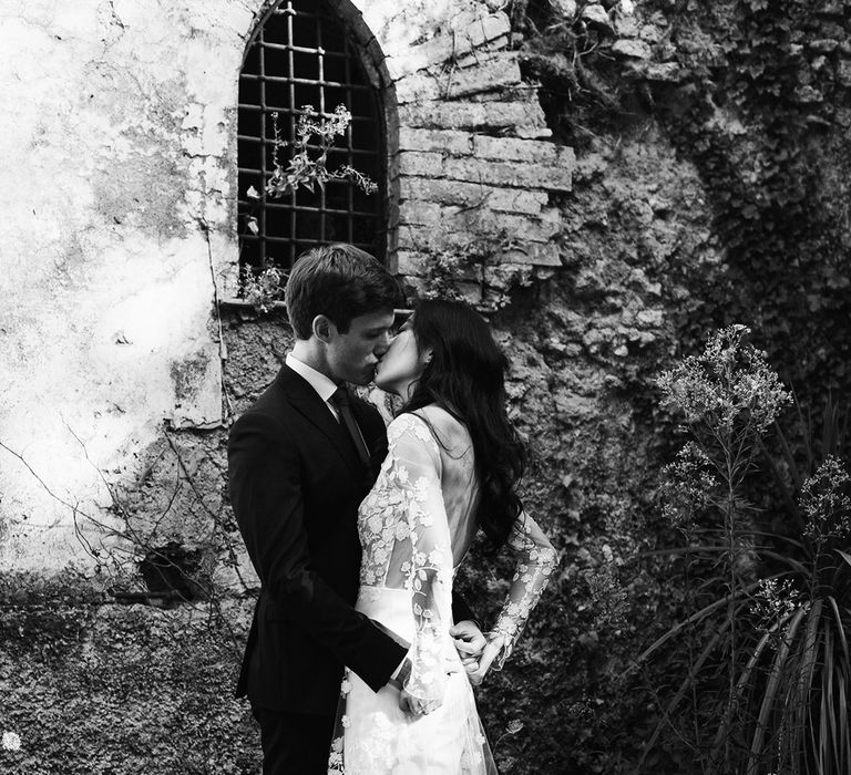 Black and white portrait of the bride and groom kissing showing off the appliqué detail on the brides wedding jumpsuit