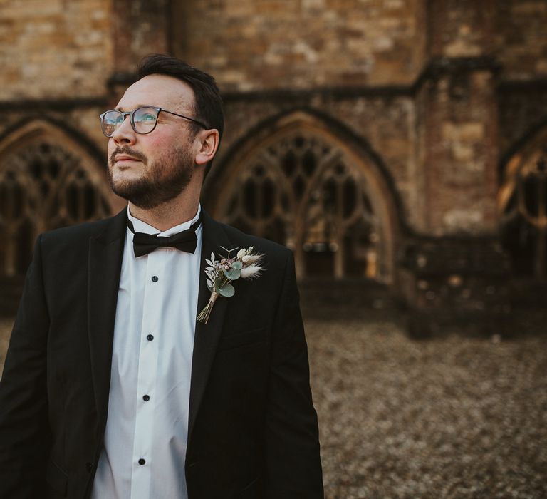 Groom in courtyard waits for bride for first-look moment 