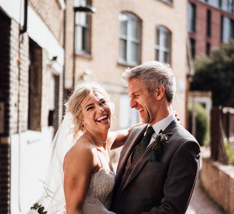 Bride & groom laugh together on the streets of London