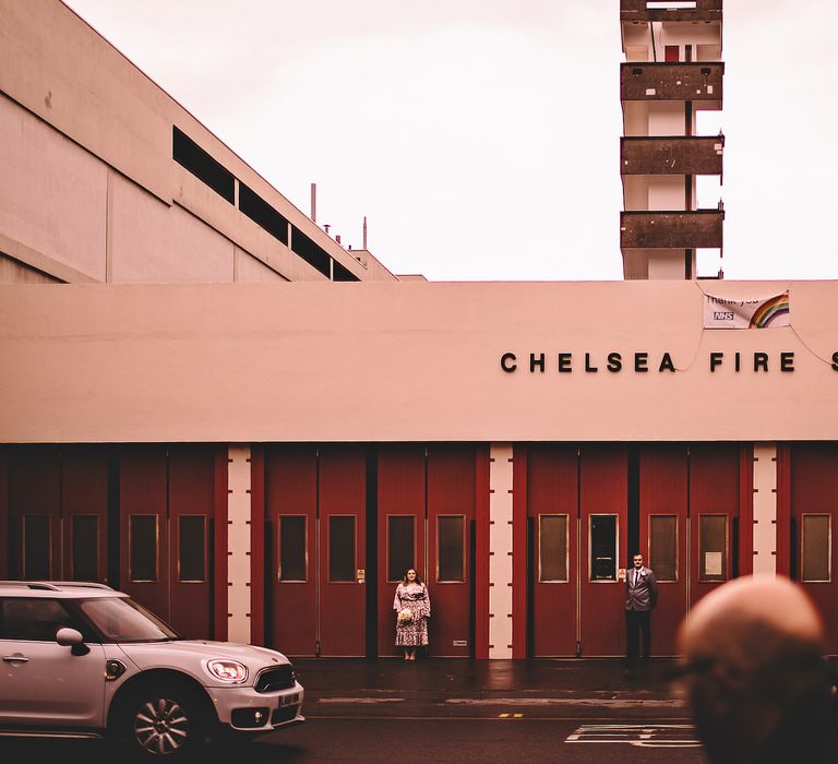 Bride & groom stand outside the Chelsea Fire Station on the morning of their wedding